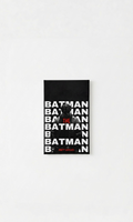 The Batman velvet wall tapestry – bold white BATMAN text stacked wall to wall with dark halftone figure emerging and red THE accent in typographic film poster style